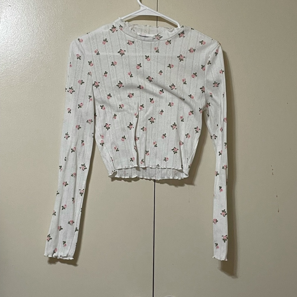 White long sleeve crop top with a green floral pattern.